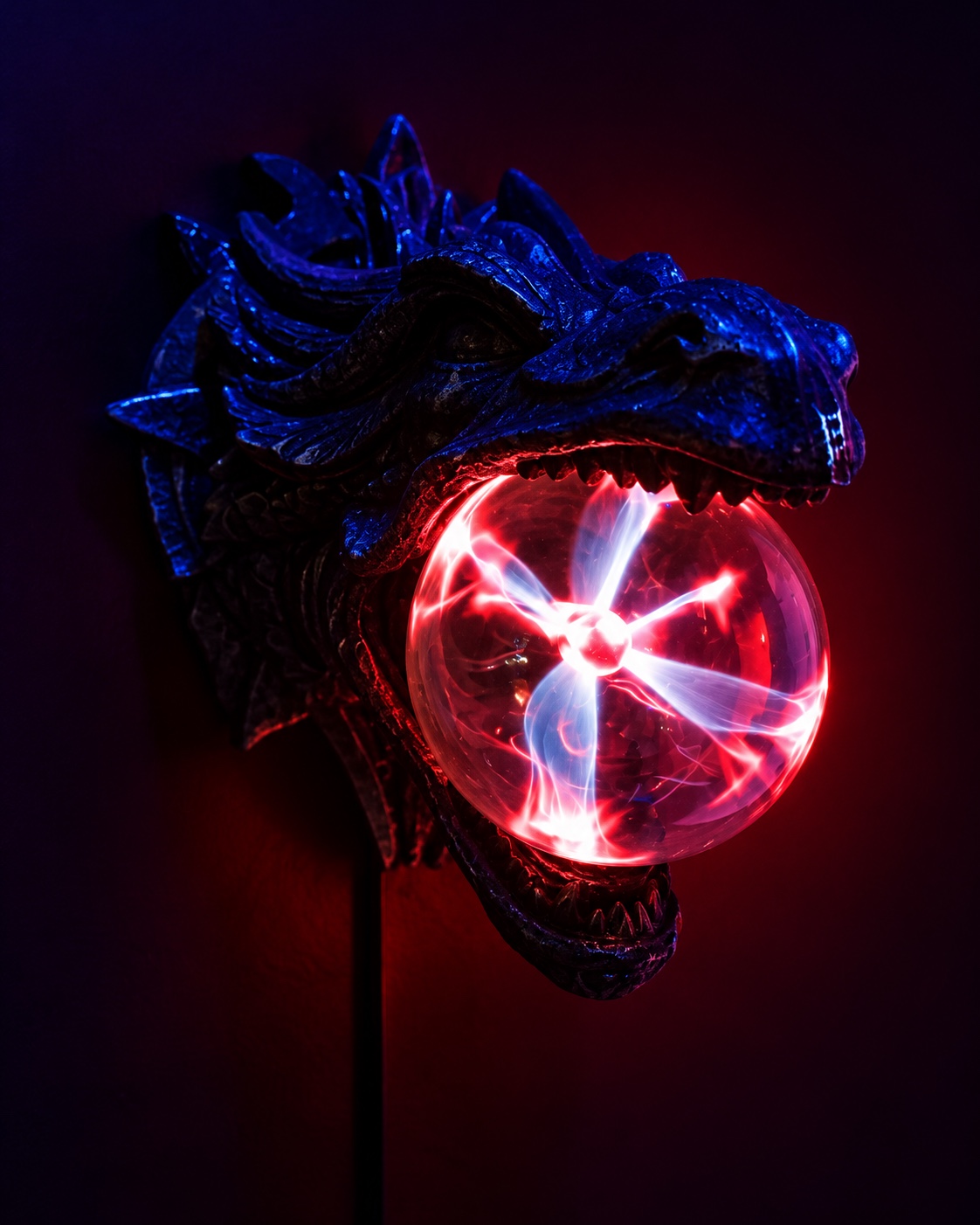 Dragon-head wall sculpture holding a glowing plasma orb