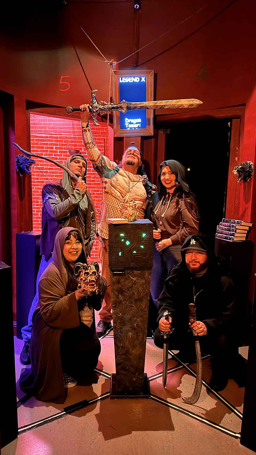 Dragon Tower team striking a playful pose with a giant sword