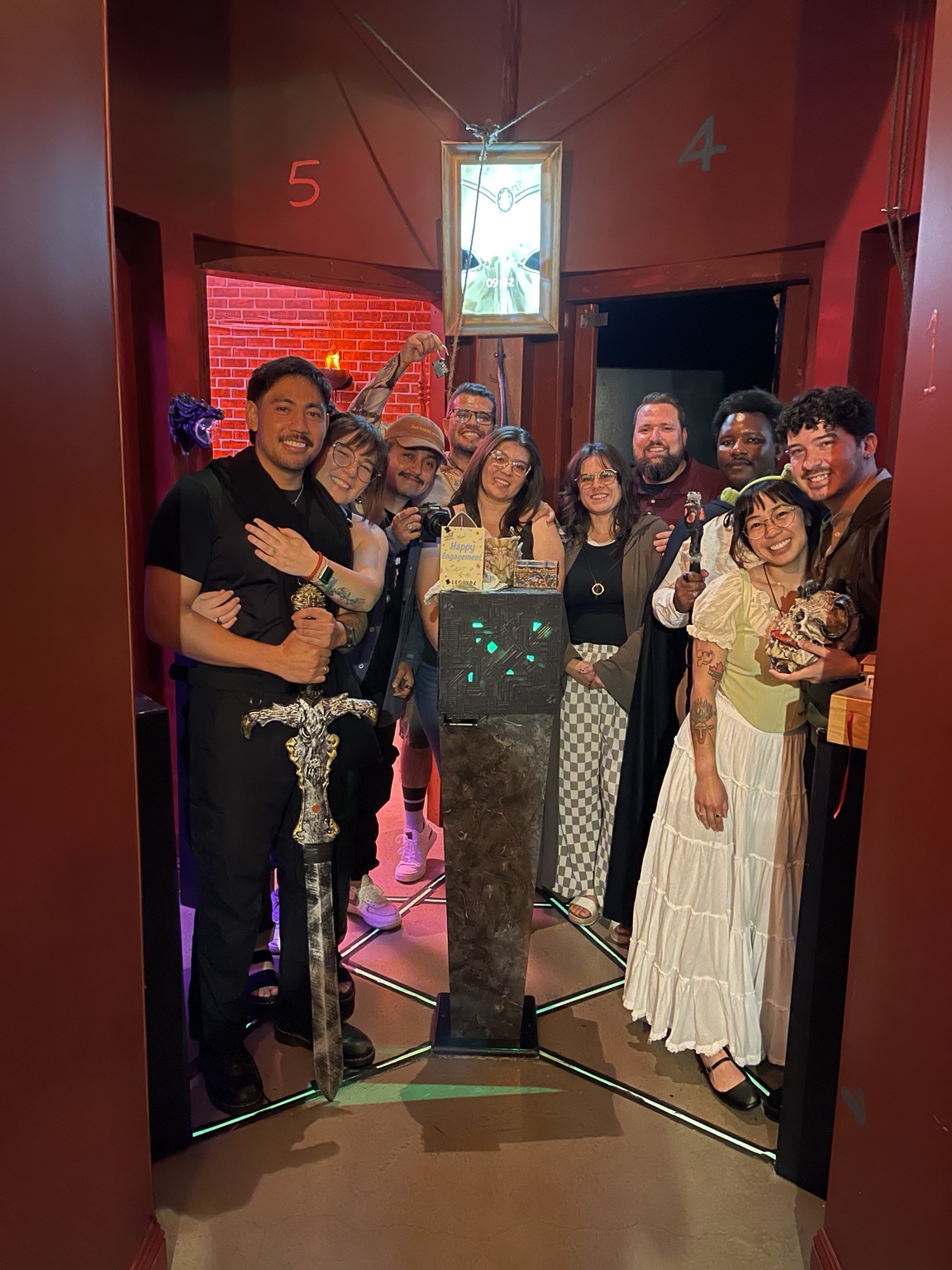 The engaged couple and their full Dragon Tower group with a Happy Engagement card